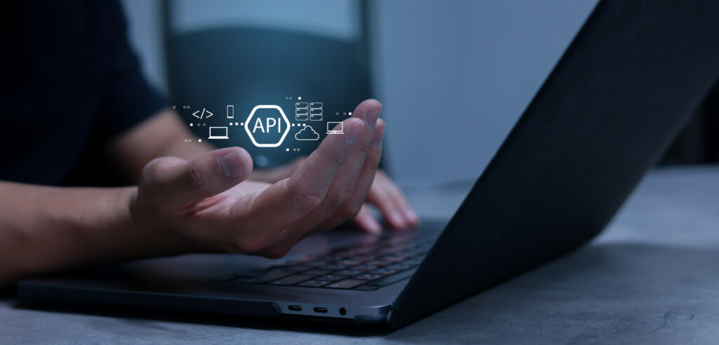 Hand toont het woord API en je ziet een laptop. Over API Connecties